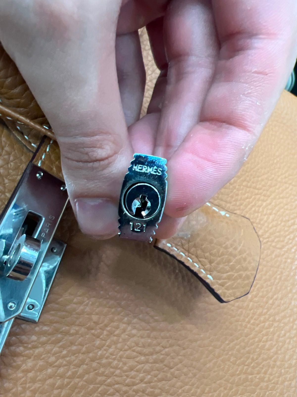 Cadeado original de bolsa Hermès autenticado durante a avaliação